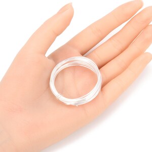 May include: A coil of silver-colored wire, approximately 18 gauge, for jewelry making.