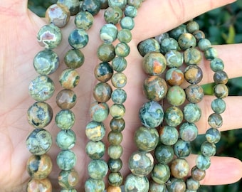 Könnte beinhalten: Mehrere Stränge grüner und brauner Edelsteinperlen. Die Perlen variieren in der Größe und weisen ein gesprenkeltes Muster auf. Die Perlen sind aufgefädelt, geeignet für Halsketten oder Armbänder.