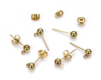 Puede incluir: Pendientes de botón dorados con detalles en forma de bola y cierres a juego dispersos sobre una superficie blanca. Los pendientes tienen un diseño simple y minimalista, adecuado para el uso diario. Los pendientes son de metal.