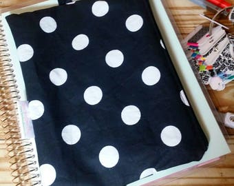May include: A black and white polka dot fabric pouch with a gold zipper. The pouch is attached to a clear plastic binder with a gold spiral.