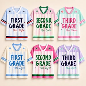 Op de afbeelding: Zes v-hals t-shirts met verticale strepen en sterren. De shirts zijn voorzien van de tekst First Grade, Second Grade of Third Grade, samen met de namen Mrs. Taylor, Mrs. Carter, Mrs. Wilson, Mrs. Davis, Mrs. Brown en Mrs. Clark.