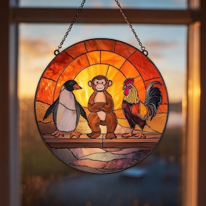 Può includere: Un pannello rotondo per finestra in vetro colorato con un pinguino, una scimmia e un gallo. Gli animali sono ambientati su uno sfondo color tramonto, con una catena per appenderlo. Il pannello è un oggetto decorativo.