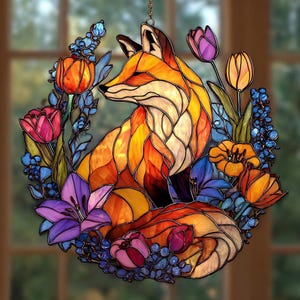 May include: Stained glass fox surrounded by colorful flowers. The fox is depicted in shades of orange, yellow, and brown, with a black nose and ears. The flowers include tulips, lilies, and other blooms in shades of pink, purple, orange, and blue.