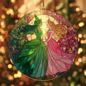 May include: A round stained glass window featuring two figures in long gowns, holding hands. One figure is in a green dress and the other in a pink dress. The background has a warm, golden glow, with floral and leaf details.