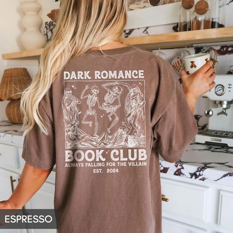 a woman standing in a kitchen holding a cup of coffee