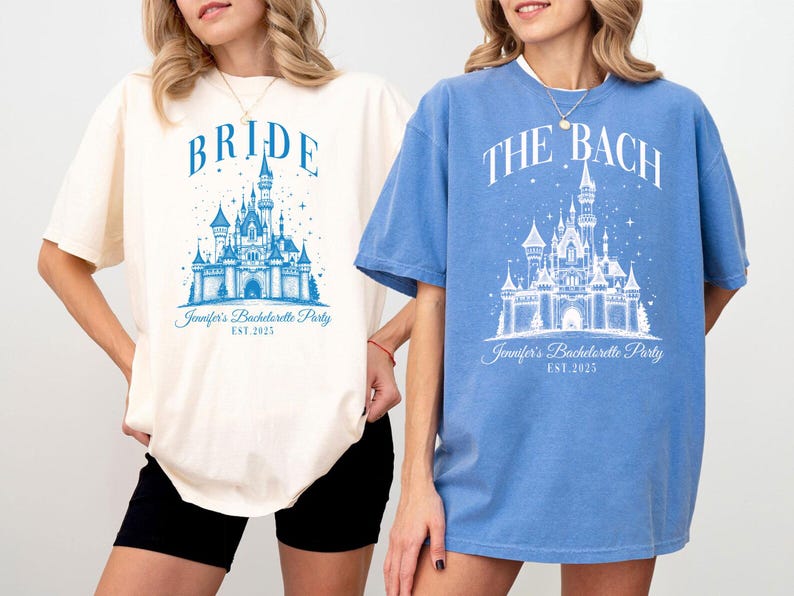 Two women wearing t-shirts with a castle design and text related to a wedding or bachelorette party.