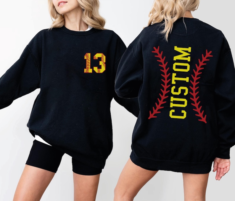 a woman wearing a black baseball sweatshirt with the number thirteen on it