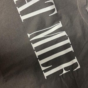 a close-up view of a grey fabric with white text printed on it.