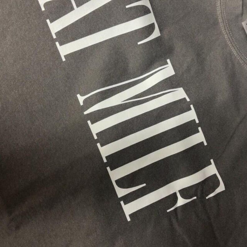 a close-up view of a grey fabric with white text printed on it.