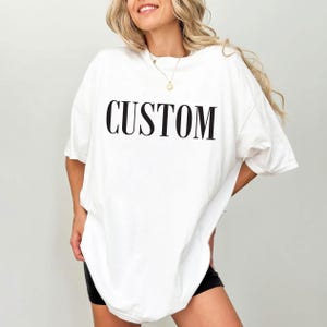 A woman wearing a white t-shirt with the word "CUSTOM" printed on it.