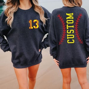 two women wearing matching sweatshirts on the beach