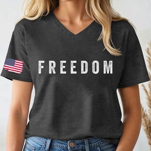 A woman wearing a black t-shirt with the word "FREEDOM" printed on it.