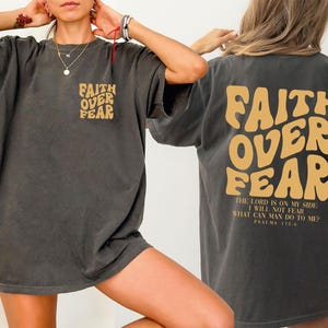 a woman wearing a faith over fear t - shirt