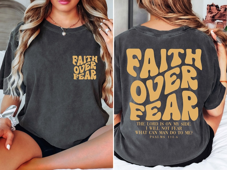 a woman sitting on a bed wearing a shirt that says faith over fear