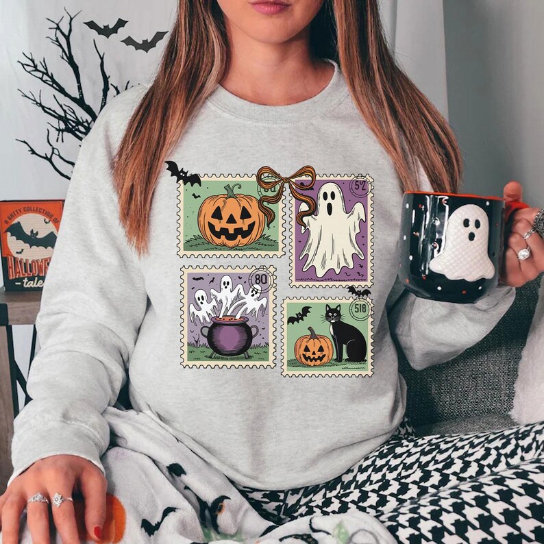A woman wearing a grey sweatshirt with Halloween-themed stamps and holding a mug with a ghost design.