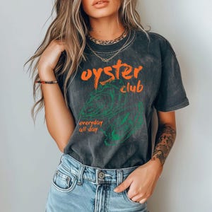 a beautiful young woman wearing a black shirt and jeans