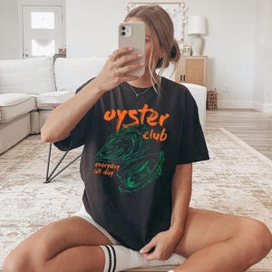 a woman sitting on the floor taking a selfie