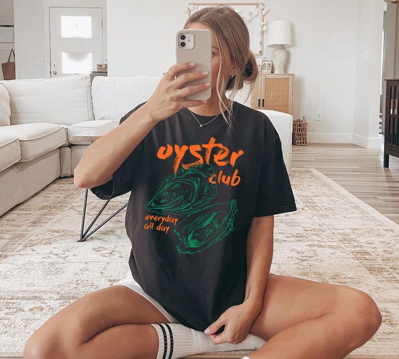 a woman sitting on the floor taking a selfie
