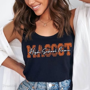 A woman with long brown hair is smiling and wearing a black tank top with the text "High School Name" printed on it.