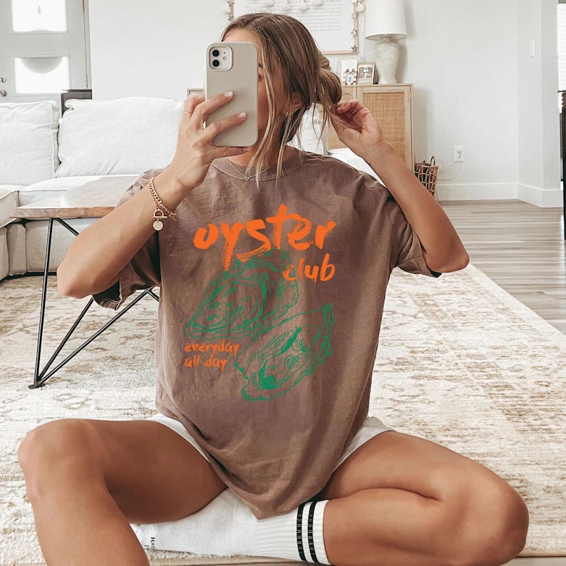 a woman sitting on the floor taking a selfie