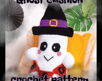 May include: A handmade crochet ghost cushion wearing a black witch hat with a purple band and gold buckle. The ghost has black eyes, pink cheeks, and a red and black outfit. The text "Ghost cushion crochet pattern" is displayed.