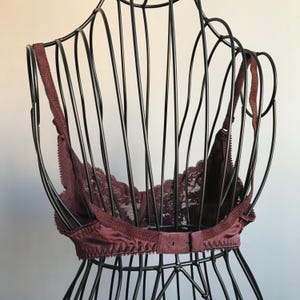 May include: A burgundy lace bra with adjustable straps and a hook and eye closure in the back.