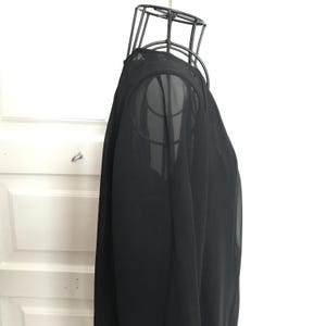 May include: A black sheer long-sleeved top with a loose fit.