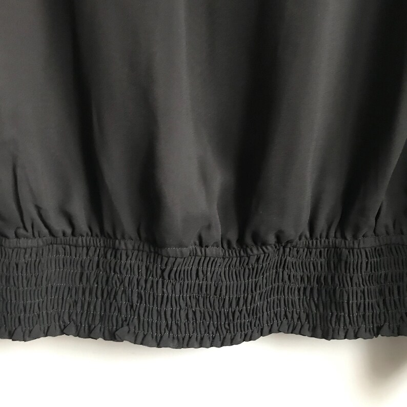 May include: Black top with a gathered elastic waistband.