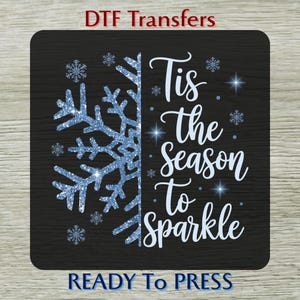 May include: A black square DTF transfer with a blue glitter snowflake design on the left and the words "Tis the Season to Sparkle" in white script on the right. The words "READY To PRESS" are at the bottom.