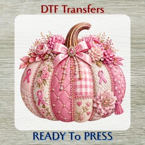 May include: A DTF transfer featuring a decorative pumpkin in shades of pink and white. The pumpkin is adorned with pink flowers, a satin bow, pearl accents, and pink ribbon symbols. The text DTF Transfers and READY TO PRESS is visible.