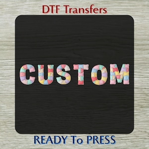 May include: A black background with the word "CUSTOM" in colorful patchwork letters. The text "DTF Transfers" is at the top, and "READY To PRESS" is at the bottom.