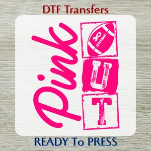 May include: A DTF transfer sheet featuring the bright pink text Pink OUT. The word Pink is written in a large script font, while the letters U and T are inside pink squares. A pink football graphic with a ribbon symbol is above the letter U.