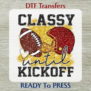 May include: A DTF transfer design featuring a football and helmet with the words "Classy until Kickoff." The design includes a football, a maroon helmet, and a gold glitter background. The words "Ready to Press" are at the bottom.