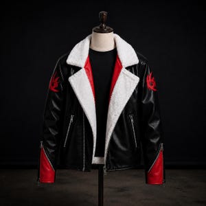 Könnte beinhalten: Eine schwarze Jacke mit weißem Kunstfellkragen und Revers. Die Jacke verfügt über rote Akzente an der inneren Knopfleiste und den Ärmelbündchen, silberfarbene Reißverschlüsse an Taschen und Ärmeln sowie ein rotes Emblem auf jeder Schulter.