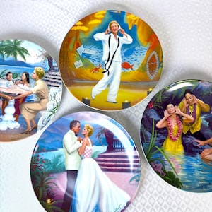 May include: A set of decorative plates with vibrant illustrations. One plate shows a woman in white, another a couple in formal wear, and others depict tropical scenes with people, all in a circular design.