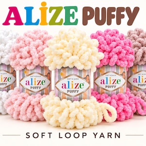 Op de afbeelding: Vijf bollen Alize Puffy zacht lusgaren op een rij. De kleuren van links naar rechts zijn wit, lichtroze, crème, felroze en oudroze. Elke bol heeft een label met de tekst Alize Puffy, Soft & Quick.