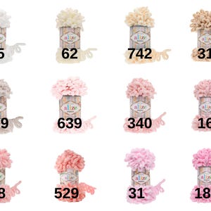 Puede incluir: Una colecci&oacute;n de 10 ovillos de lana en varios tonos de blanco, beige y rosa. Cada ovillo est&aacute; etiquetado con el nombre de la marca "Alize" y un n&uacute;mero.