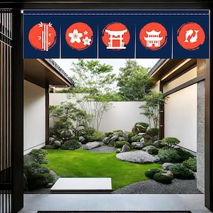 May include: A Japanese-style garden with a small, manicured lawn, gravel, and rocks. The garden is framed by a wooden structure with a blue and red fabric hanging above the entrance. The fabric features five red circles with white Japanese symbols.