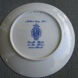 May include: A white ceramic plate with blue text and a blue crest. The text reads "Father's Day 1970" and "Castle Pfalz in the Rhine near Kaub."