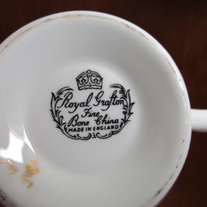 May include: Close-up of the bottom of a white teacup with a black and white Royal Grafton Bone Fine China stamp and a gold number 188.