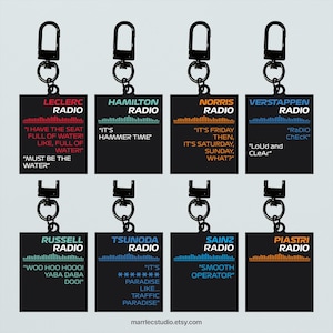 Könnte beinhalten: Acht schwarze Schlüsselanhänger mit rechteckigen Anhängern mit Rennteamnamen und Zitaten. Die Schlüsselanhänger enthalten die Namen Leclerc, Hamilton, Norris, Verstappen, Russell, Tsunoda, Sainz und Piastri. Jeder Anhänger hat ein grafisches Equalizer-Design und ein Zitat.
