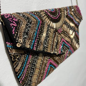 Cartera de mano con cuentas de colores de la colección Sfera Femme con correa de cadena de metal