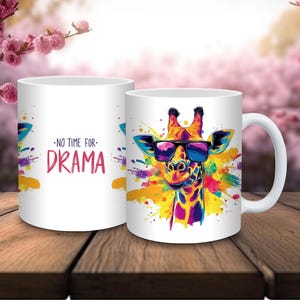 Pode incluir: Caneca de cerâmica branca com uma girafa colorida usando óculos de sol, contra um respingo vibrante de tinta. A caneca também exibe o texto "NO TIME FOR DRAMA" em rosa. A caneca tem uma alça branca.