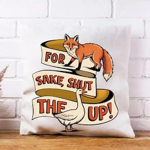 May include: A white square pillow with a humorous design. It features a cartoon fox and goose with the text "FOR SAKE, SHUT THE UP!". The fox is orange and the goose is white.