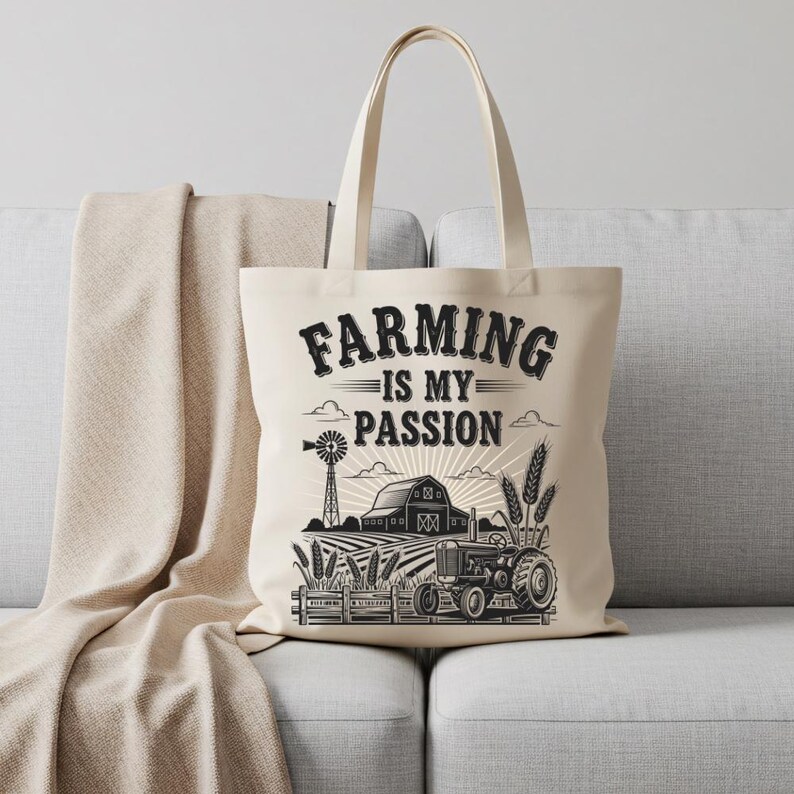 May include: Cream-colored tote bag with the text "FARMING IS MY PASSION" in a black, vintage font. The design includes a tractor, barn, windmill, and wheat stalks, all in black and white. The bag has a simple, rectangular shape.