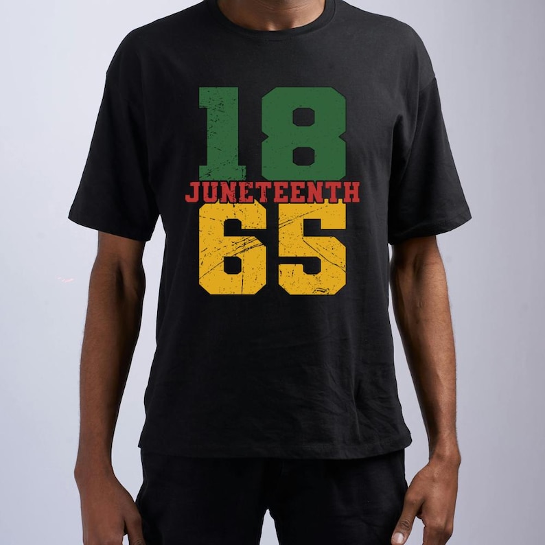 Pu&ograve; includere: T-shirt nero con la scritta "18 Juneteenth 65" in verde, rosso e giallo. I numeri e il testo hanno un aspetto invecchiato e vintage. La maglietta &egrave; a maniche corte.