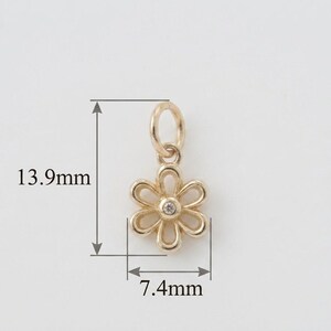 May include: A gold-colored flower charm with a small diamond in the center. The charm is 0.55 inches long and 0.29 inches wide. It has a loop at the top for attaching to a necklace or bracelet. The charm is set against a white background.