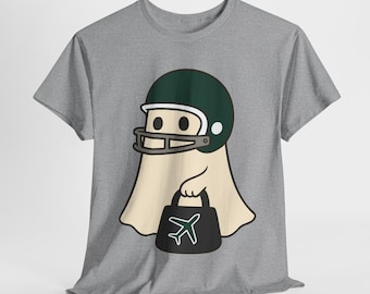 Könnte beinhalten: Graues T-Shirt mit einem Cartoon-Geist, der einen grünen Footballhelm trägt. Der Geist hält eine schwarze Tasche mit einer weißen Flugzeuggrafik. Das Design ist auf dem T-Shirt zentriert.
