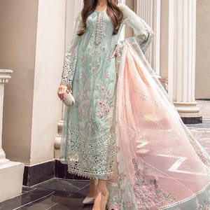 May include: A light blue and pink embroidered dress with a long skirt and long sleeves. The dress has a delicate floral pattern and is made of a sheer fabric.