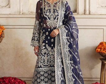 Puede incluir: Conjunto de ropa formal bordada en azul marino. El atuendo presenta intrincados bordados plateados en el corpiño, las mangas y la falda. Un dupatta transparente y fluido con bordados a juego completa el look. Adecuado para ocasiones especiales.